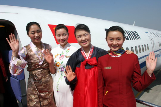 圖2：藏族空乘達(dá)娃卓瑪（左一）、朝鮮族空乘金成淑（右二）和身穿旗袍的陳菲菲（左二）在艙門迎接代表登機(jī)